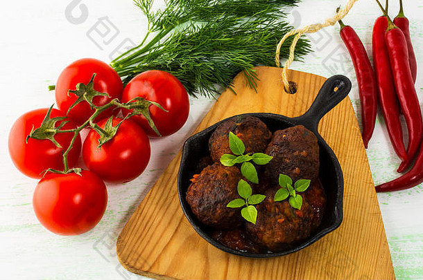 用铸铁平底锅盛有辣椒和西红柿的烤肉丸。烤肉卷。烤肉丸子。