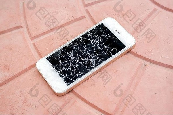 损坏的智能手机屏幕。在瓷砖地板上有一个坏屏幕的智能手机。侧视图坏了的手机。疏忽