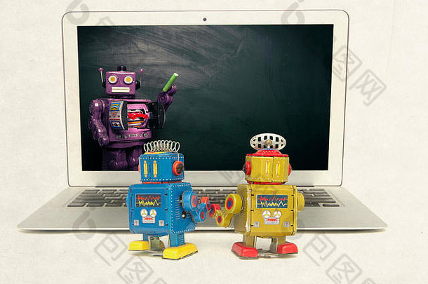 两个复古机器人在一台笔记本电脑上学习东西