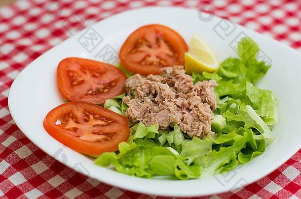 金鱼鱼肉配蔬菜沙拉和红番茄。