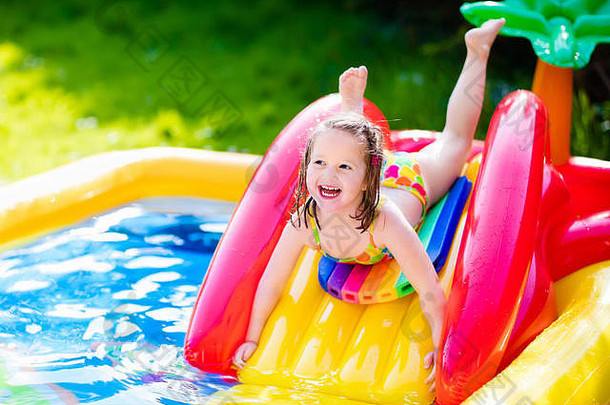孩子们在充气婴儿池里玩耍。孩子们在五颜六色的花园游戏中心游泳和嬉戏。
