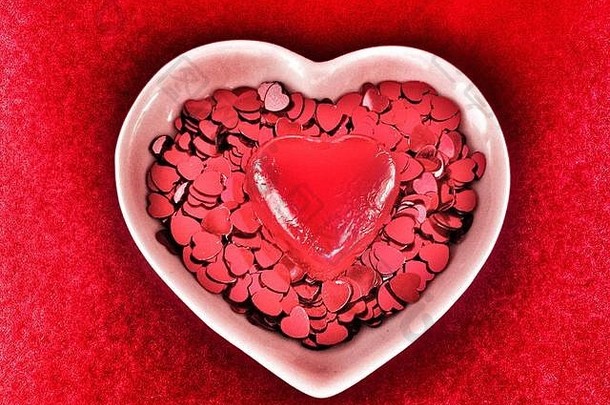 情人节一天红色的心洒红色的巧克力心白色心形状的陶瓷菜红色的背景