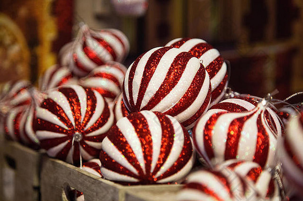 白色和红色条纹的玻璃圣诞球堆放在装饰店的货架上