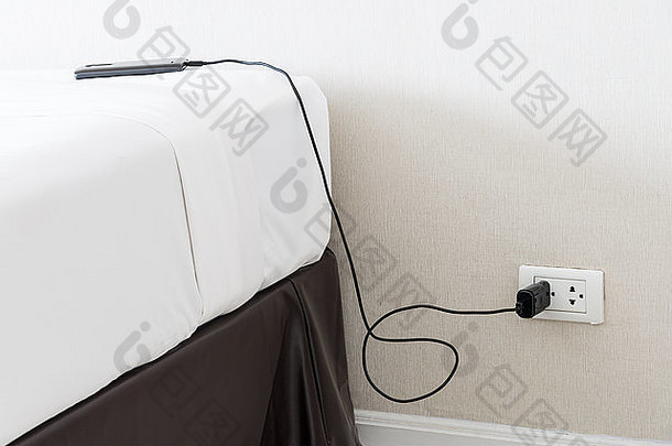 卧室里带墙上插座的<strong>手机充电器</strong>。