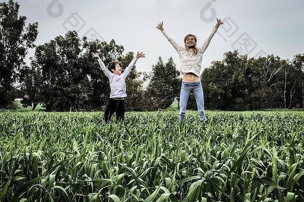 妈妈和孩子在田野里跳跃