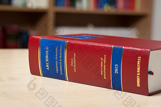 Archbold 2013法律书籍的特写照片，坐在办公室的桌子上，书架上放着法律书籍。