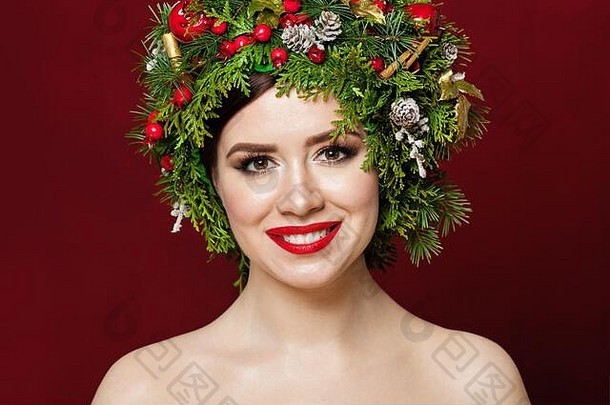 美丽的女人穿圣诞节装饰红色的背景