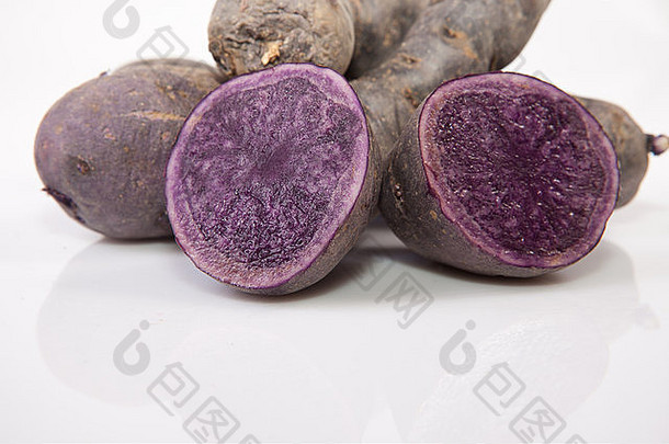 切成片的和整片的紫色维特罗特土豆。在白色背景上隔离