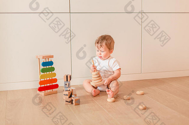 可爱的婴儿男孩玩叠加环房间