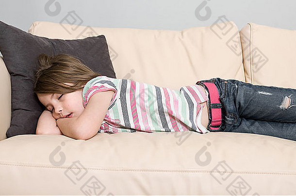 一个小孩睡在皮沙发上的可爱照片