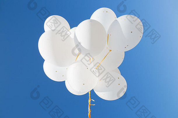 蓝色天空中白色氦气球的特写镜头