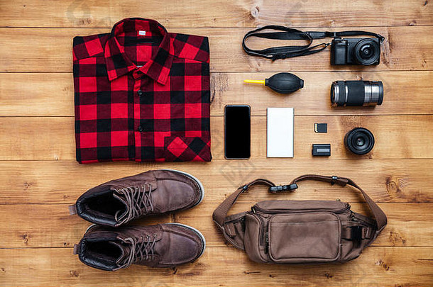 旅行概念靴、衬衫、相机、手机、mp3、耳机、书桌上的包