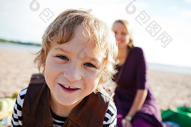 肖像快乐男孩海滩妈妈。背景