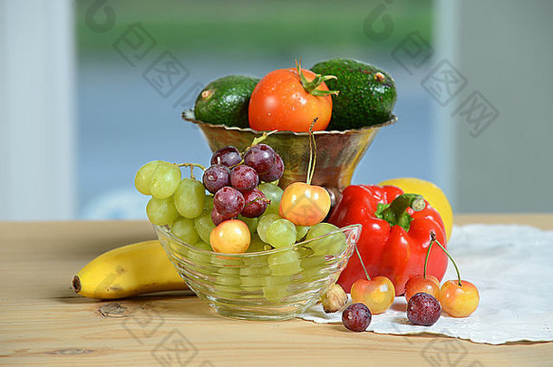 厨房窗户旁边桌子上摆放着各种新鲜水果和蔬菜