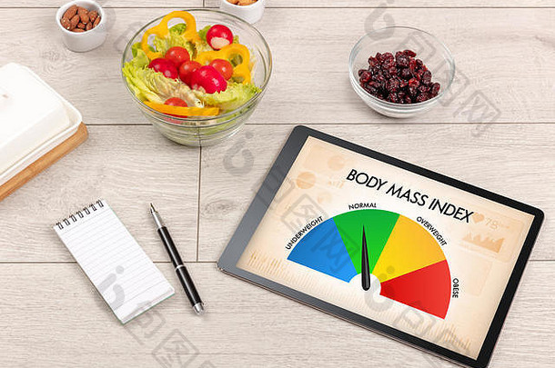 健康食品，木质背景上有平板，上面写着“身体质量指数”。健康概念。