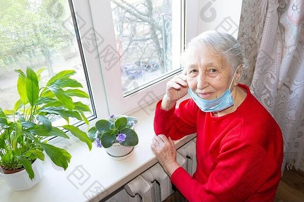 2019冠状病毒疾病、健康、安全和流行病概念——坐在窗前的老太婆