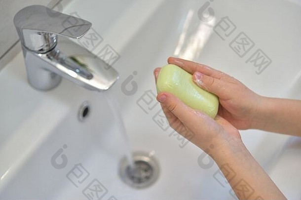 用肥皂洗手的特写镜头。用肥皂洗手，在水龙头下面用水。清洁卫生理念。