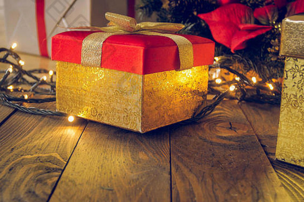 特写镜头健美的图像金盒子礼物木桌子上发光的圣诞节灯