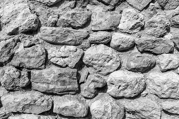 古砖墙的背景。用于设计的旧圆形剧场石头的纹理。单色