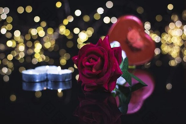 情人节一天背景礼物丝带红色的玫瑰蜡烛五彩纸屑黑色的背景心形状散景灯情人节一天概念