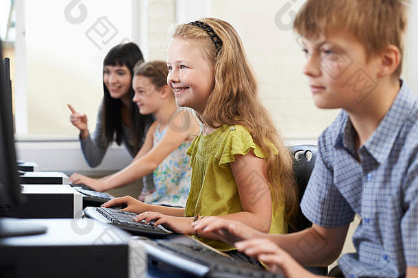 小学生与老师一起上计算机课