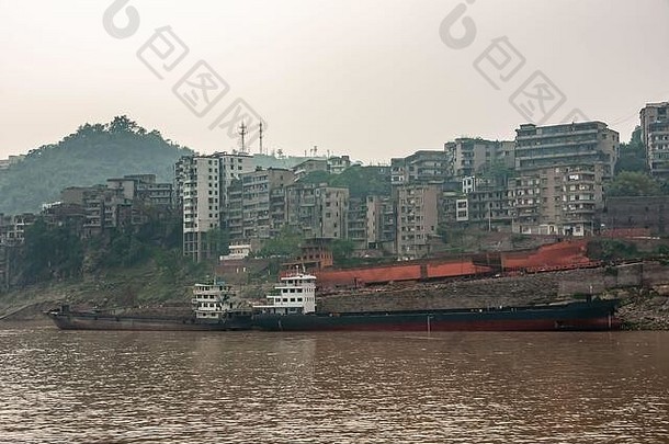 Myaoyinan，重庆，中国-2010年5月8日：长江。正在建造的大型内河船的红色残骸躺在岸上。在brown wate完成1
