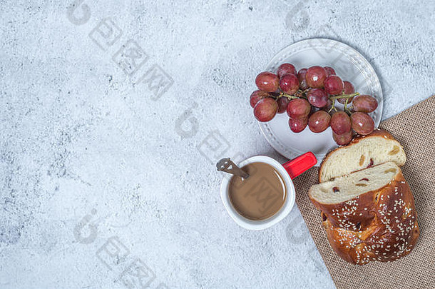 平躺，早餐早午餐放在桌子上。盘子上放葡萄，一杯咖啡和面包的概念食品饮料。