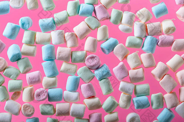 粉红色背景上的棉花糖。彩色迷你棉花糖。顶视图。