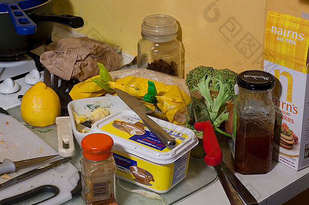 厨房工作台面上凌乱的一堆食物和刀具