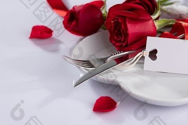 表格设置白色纸卡白色盘子餐具装饰纺织白色背景红色的花