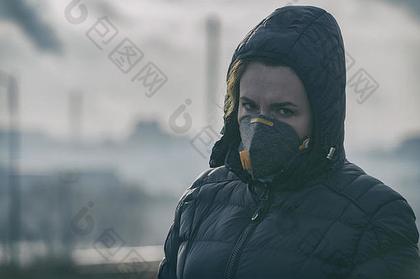 妇女戴着真正的防污染、防烟雾和病毒面罩；空气中浓密的烟雾。