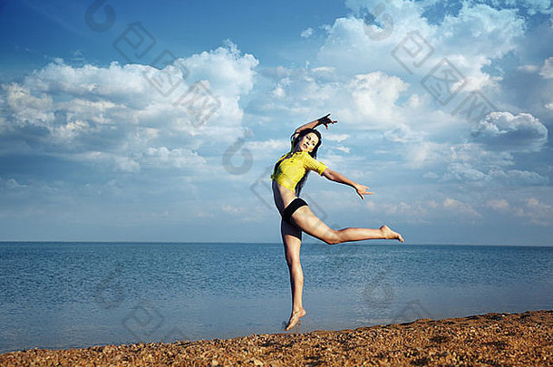 夏日海滩上跳舞跳跃的女士