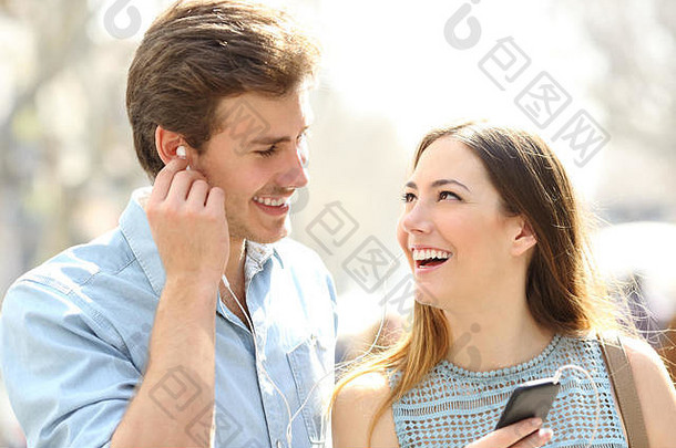 快乐浪漫的情侣在街上分享在线音乐约会
