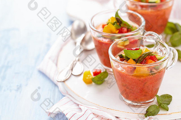 冷番茄汤（gazpacho），装在木制砧板上的小杯中。