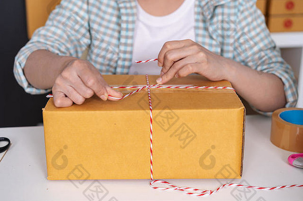 手女人企业家系绳子包装产品包裹盒子准备交付客户首页办公室