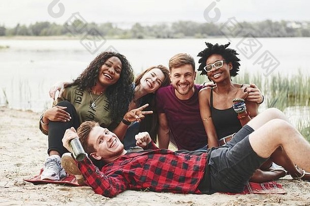 说谎坐着集团人野餐海滩朋友有趣的周末时间