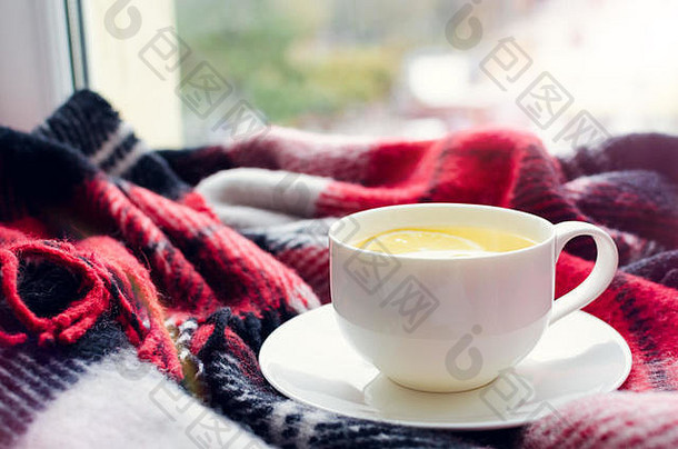一杯柠檬茶和温暖的羊毛毯放在窗台上。雨天的热饮。潮格概念，<strong>秋意</strong>。舒适的冬天早晨在家里。温暖的