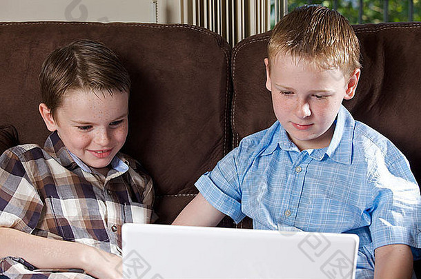两兄弟在家使用笔记本电脑