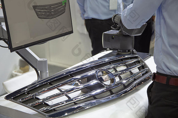 工业工人使用手持式3D扫描仪检查汽车格栅