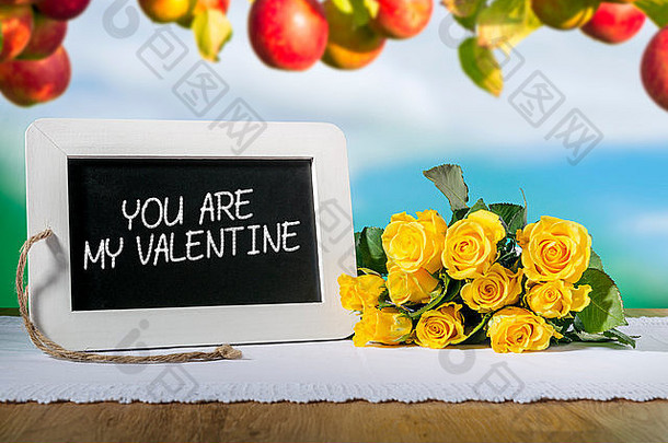 一块石板黑板上的图像，上面写着“你是我的情人”，背景是黄色的玫瑰和苹果