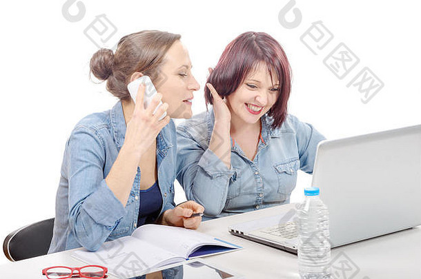 两位微笑的女商人在办公室使用手机