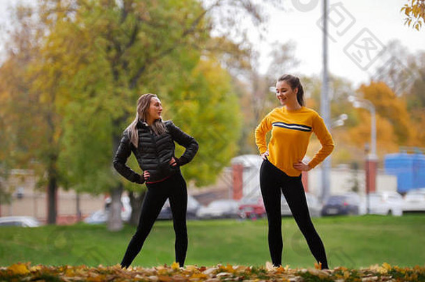穿着毛衣的女孩们在公园训练前在室外热身。