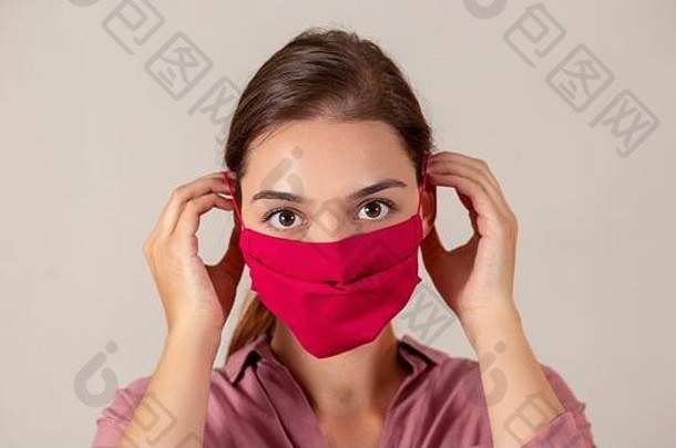 年轻的女护士把红色的织物医疗面具流感大流行