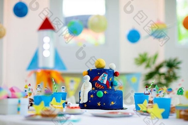 儿童空间主题生日派对，蛋糕和纸杯蛋糕。火箭，太阳系行星和宇航员装饰儿童活动。小桌子的摆设