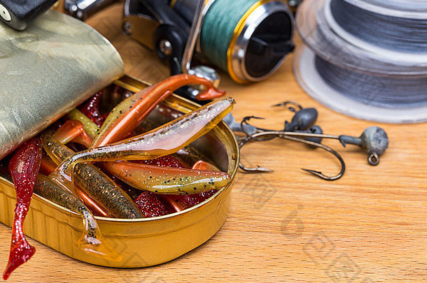 钓鱼用具Swimbait在木质背景的开放式罐中使用不同的颜色