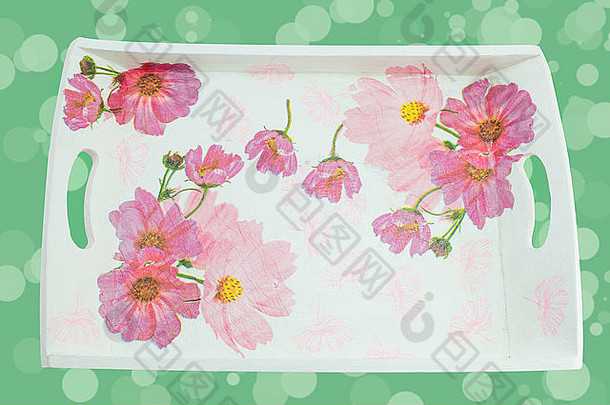 在柔和的粉红色背景下装饰有花朵图案的装饰托盘