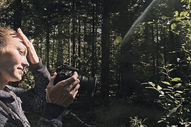 旅行者在森林里拍摄风景。一名白人女子拍摄了漂亮的魔术造型。女孩在数码单反无镜相机上拍照。