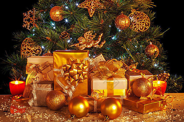 豪华圣诞树下的许多金色礼品盒的图片，装饰精美的新年云杉，闪亮的圣诞装饰