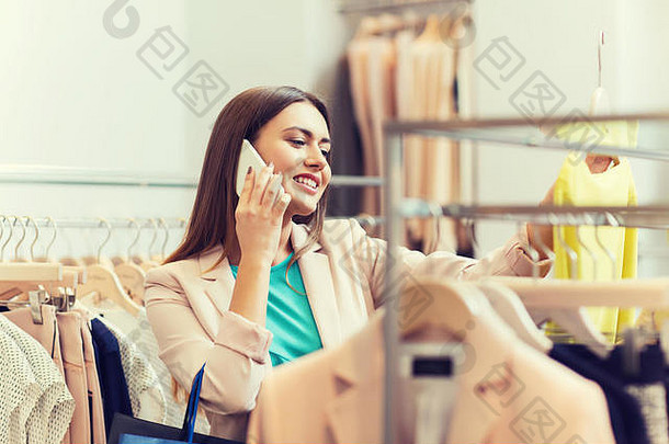 一位女士在服装店打电话给智能手机