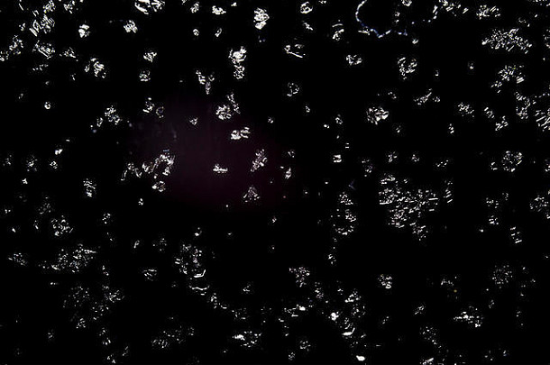 雪花覆盖着黑色背景的玻璃窗